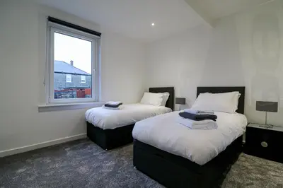 two beds in a room with a window at Marchfield Promenade View in Prestwick