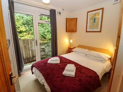 a bedroom with a bed with two towels on it at Bluebells in Ambleside