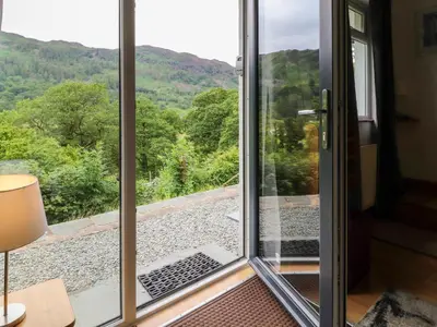 a sliding glass door with a view of the mountains at Bluebells in Ambleside