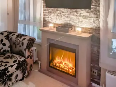 a fireplace in a living room with a chair and candles at Zion's Retreat in Plumbland
