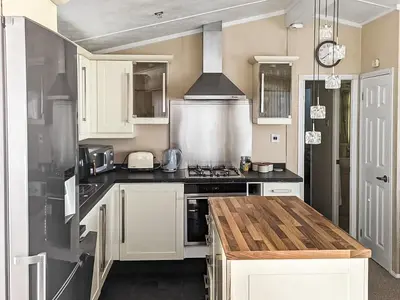 a kitchen with white cabinets and a stove top oven at Zion's Retreat in Plumbland