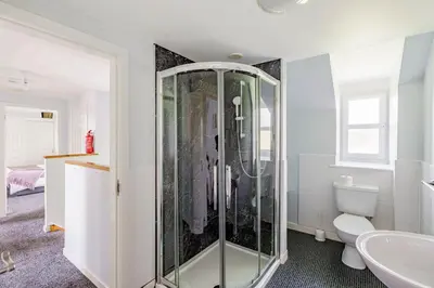 a bathroom with a shower and a toilet at Auchenlarie Courtyard No 1 in Gatehouse of Fleet