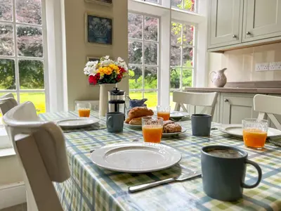 a table with a plate of food on it in a kitchen at Bank House Longtown, ideal group accommodation with swimming pool & hot tub in Longtown