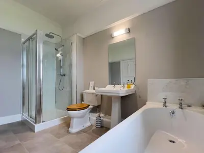 a bathroom with a tub and a toilet and a sink at Bank House Longtown, ideal group accommodation with swimming pool & hot tub in Longtown