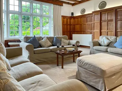 a living room with couches and a table at Bank House Longtown, ideal group accommodation with swimming pool & hot tub in Longtown