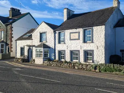 a white house on the side of a street at 4BR Holiday Home Steps from Keswick Town Centre in Keswick