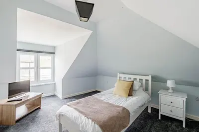 a bedroom with a bed and a desk and a tv at Auchenlarie Courtyard No 3 in Gatehouse of Fleet