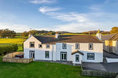 a large white house with a yard at Auchenlarie Farmhouse in Gatehouse of Fleet