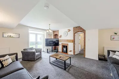 a living room with a couch and a table at Auchenlarie Farmhouse in Gatehouse of Fleet
