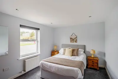 a bedroom with a bed and a window at Auchenlarie Courtyard No 5 in Gatehouse of Fleet
