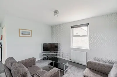 a living room with two couches and a tv at Auchenlarie Courtyard No 5 in Gatehouse of Fleet