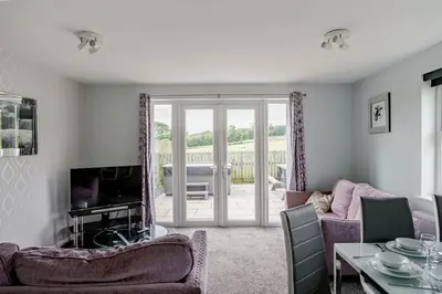a living room with a couch and a tv at Auchenlarie Courtyard No 4 in Gatehouse of Fleet