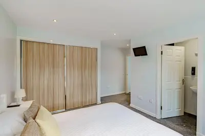 a bedroom with a large bed and a sliding door at Auchenlarie Courtyard No 4 in Gatehouse of Fleet