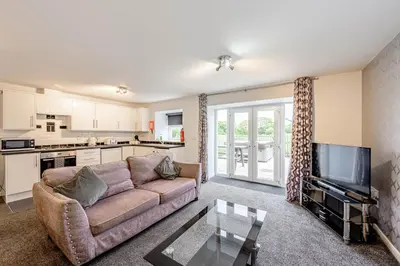 a living room with a couch and a tv at Auchenlarie Courtyard No 2 in Gatehouse of Fleet