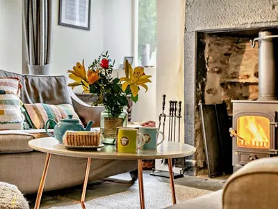a living room with a couch and a coffee table with flowers at 4 Bed in Buttermere oc-sz090 in Buttermere