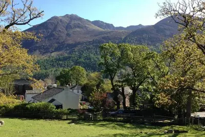 a house in a field with mountains in the background at 4 Bed in Buttermere oc-sz090 in Buttermere
