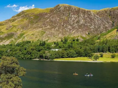 people in boats on a lake in front of a mountain at 4 Bed in Buttermere oc-sz090 in Buttermere