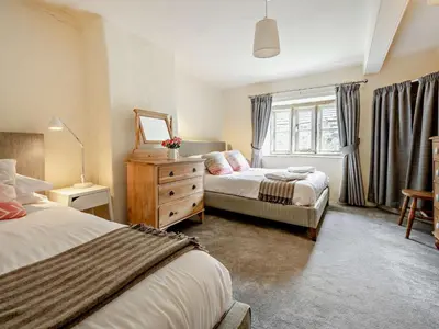a bedroom with two beds and a dresser and a window at 4 Bed in Buttermere oc-sz090 in Buttermere