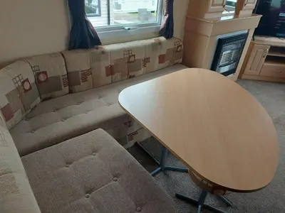 a living room with a table and a couch at Victoria's Caravans in Ayr