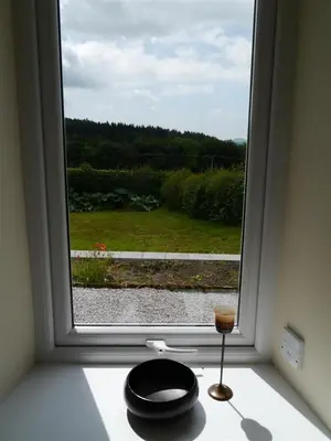 a window with a candle on a counter next to it at Swallow Cottage in Dalbeattie