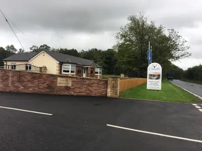 a house with a sign in a parking lot at Carlisle CAMELOT HOLIDAY PARK CA65SZ MANOR in Longtown