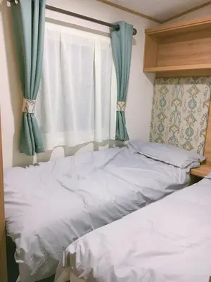 a bedroom with two beds and a window at Carlisle CAMELOT HOLIDAY PARK CA65SZ Blenheim in Longtown