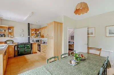 a kitchen with a dining table and a kitchen with a stove at Bellrigg in Castle Douglas