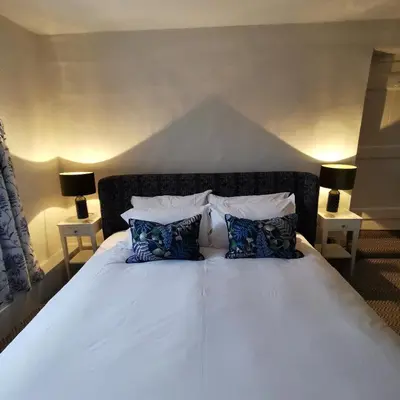 a white bed with two pillows and two lamps at The Swinside Inn in Keswick