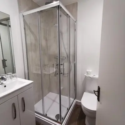 a bathroom with a shower with a toilet and a sink at The Swinside Inn in Keswick
