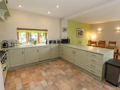 a large kitchen with white cabinets and a window at Gallery Cloisters in Keswick