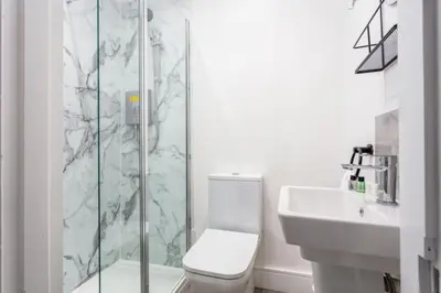 a bathroom with a shower and a toilet and a sink at St Meddans Mews in Troon in Troon