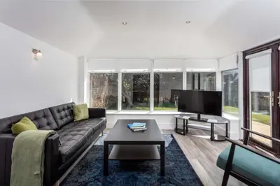 a living room with a couch and a flat screen tv at St Meddans Mews in Troon in Troon