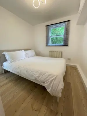 a bedroom with a bed with white sheets and a window at The Ship Inn's Cabin in Gatehouse of Fleet