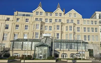 a large building with a glass structure in front of it at The Empress Hotel in Douglas