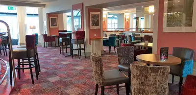 a restaurant with chairs and tables and a bar at The Empress Hotel in Douglas