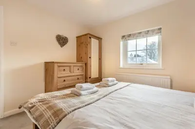a bedroom with a large white bed and a window at 3 Bed in Workington oc-92628 in Dean