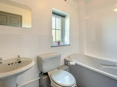 a white bathroom with a toilet and a sink at 3 Bed in Workington oc-92628 in Dean