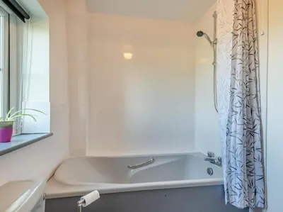 a white bath tub in a bathroom with a shower curtain at 3 Bed in Workington oc-92628 in Dean