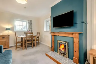 a living room with a fireplace with a flat screen tv at 3 Bed in Workington oc-92628 in Dean