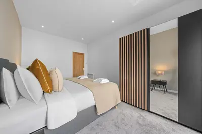 a bedroom with a large white bed with pillows at The Manor - Beachwalk Apartments in Ayr