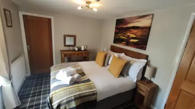 a bedroom with a bed with yellow and white pillows at The Boot Inn in Boot