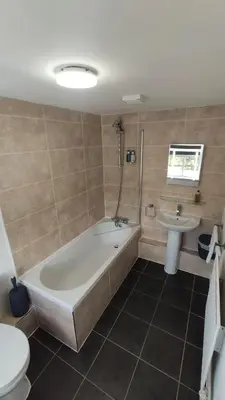 a bathroom with a tub and a toilet and a sink at The Boot Inn in Boot