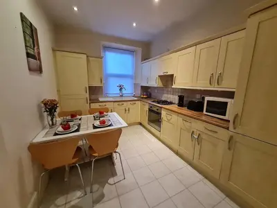 a kitchen with yellow cabinets and a table with fruits on it at Douglas Head Road in Douglas
