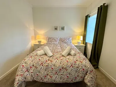 a bedroom with a large bed with two pillows at Country Cottage on Private Estate in Minishant