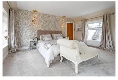 a bedroom with a large bed and a chair at Brig o Doon House Alloway in Ayr
