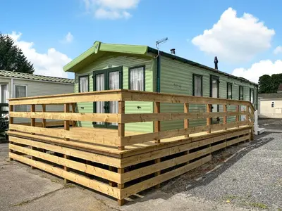 a green tiny house on a wooden deck at Peppy in Newton Stewart