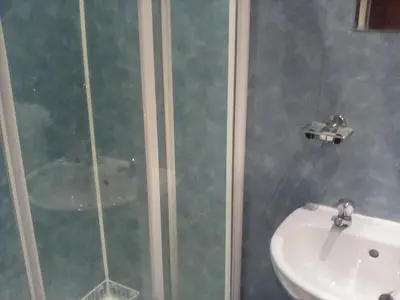 a bathroom with a shower and a white sink at The Merchants House in Cairnryan