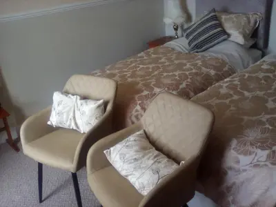 a bedroom with two chairs and a bed at The Merchants House in Cairnryan