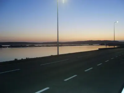 a road with a street light and a body of water at The Merchants House in Cairnryan
