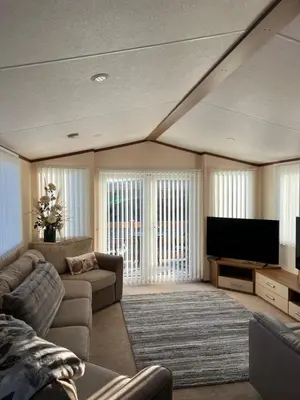 a living room with a couch and a flat screen tv at Maneight Fir View with hot tub in Dalleagles